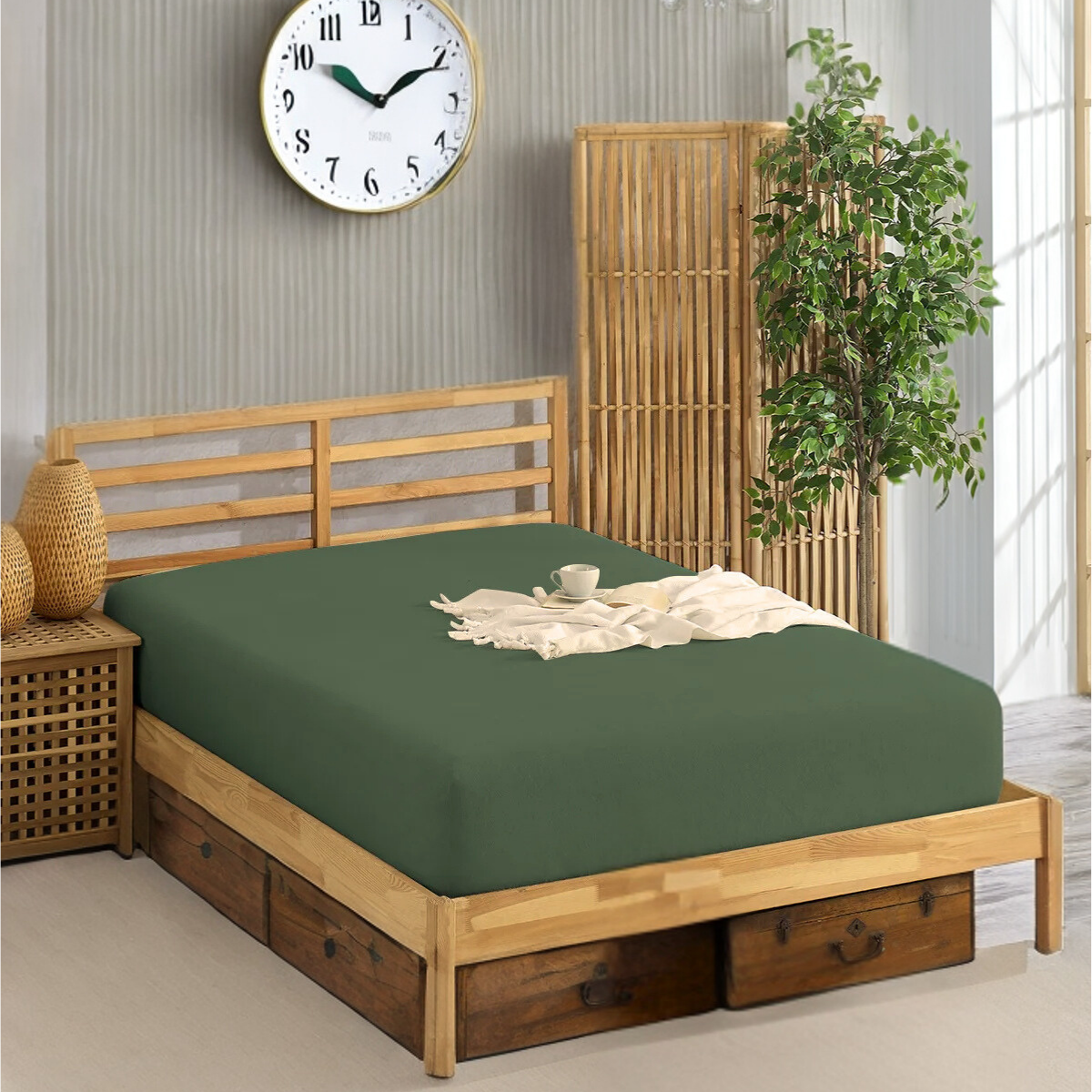Grünes Spannbettlaken - auf einem Holzbett mit passgenauem, dunkelgrünem Laken und einer weißen Decke.